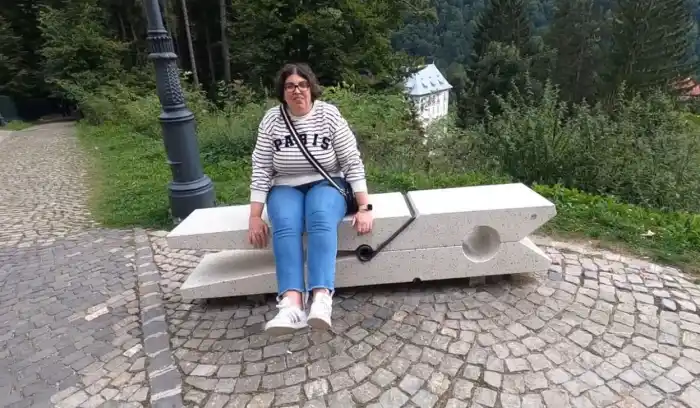 ana delante del monasterio de sinaia sentada en una pinza de ropa transformada en banco