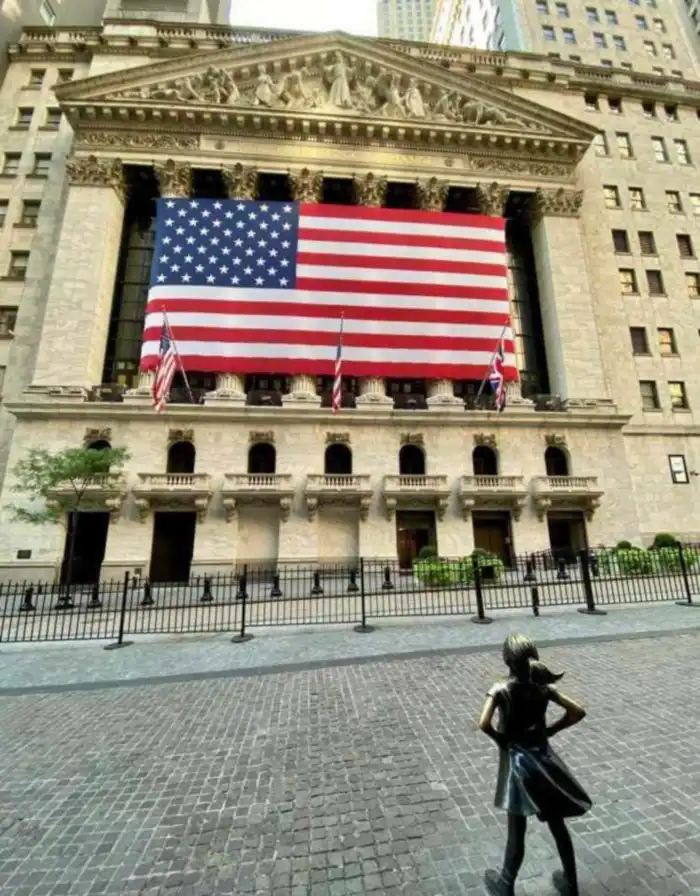 bolsa de nueva york y niña sin medio enfrentandose