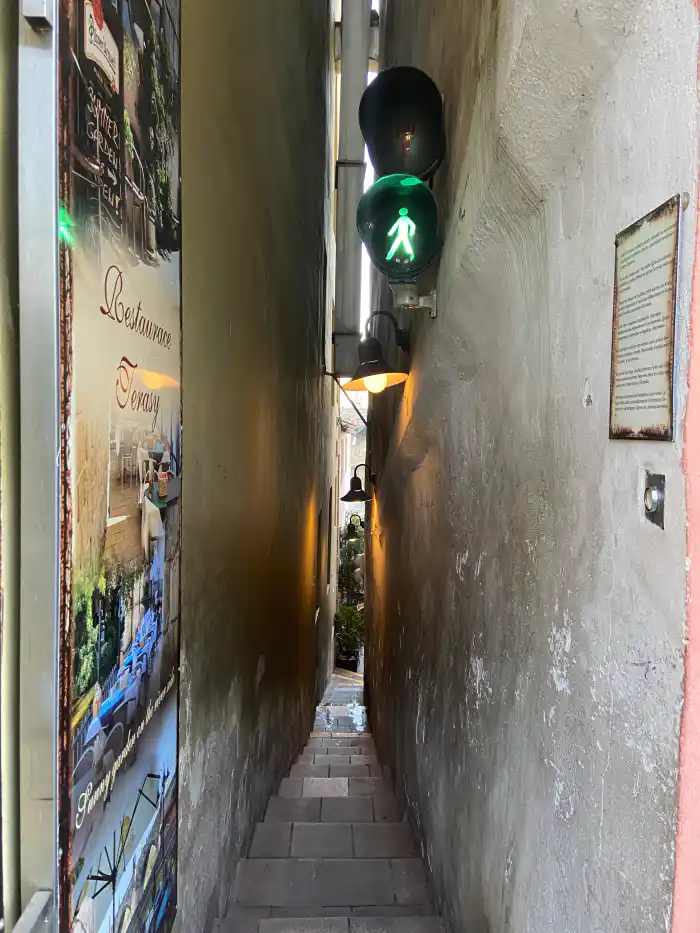 calle mas estrecha de praga con un semaforo en cada esquina para controlar las personas que van de un lado hacia el otro